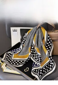Silk scarf with stripes and houndstooth pattern draped over a brown leather handbag