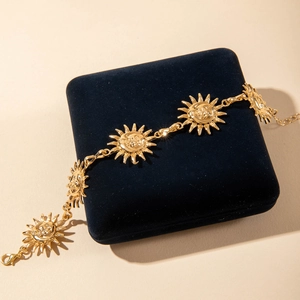 Detailed view of vintage sun face charms and lobster clasp on golden alloy anklet