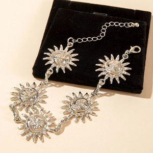 Detailed close-up of retro silver alloy anklet featuring sun face pendants and lobster clasp