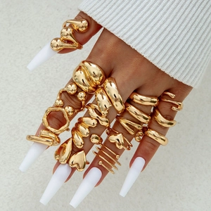 Golden chunky rings set featuring irregular oval and heart designs on a hand