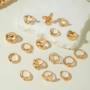 Flat lay of 15 gold plated fashion rings set with heart and geometric spiral designs