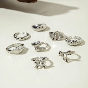 Détails d'un ensemble de bagues en argent poli aux designs de nœuds et vagues texturées