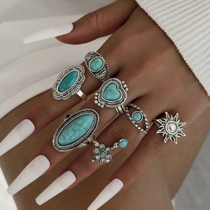 Detail of vintage silver boho ring set with turquoise stones and floral engravings