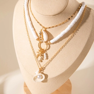 Collier multicouche bohème doré avec pendentifs coquillages et détails de perles blanches