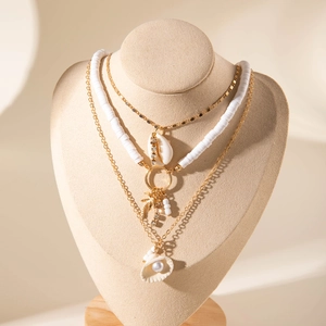 Collier multicouche bohème avec coquillage et perles sur présentoir beige chic