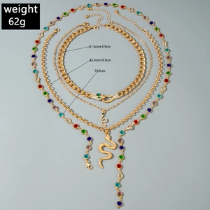 Macro shot of layered gold snake necklaces with dimension labels and colorful stones