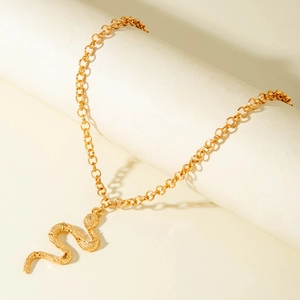 Minimalist gold serpent snake pendant necklace with layered chain on cream display stand