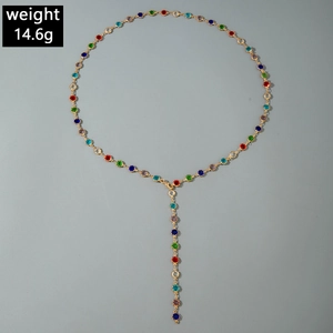 Detail of bohemian gold-tone Y-necklace featuring vibrant multi-colored inlaid gemstones