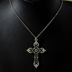 Macro view of vintage silver gothic cross pendant with black enamel and hollow detail