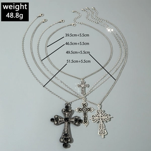 Detailed view of gothic hollow cross pendants with layered zircon chains and retro patterns