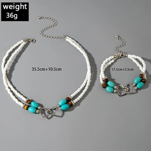 Detail of beaded necklace and bracelet set with turquoise beads and metal heart charms