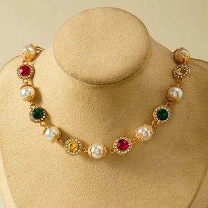 Macro view of vintage baroque gold necklace with colorful gemstones and pearls