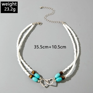 Detail view of bohemian double-layer bead necklace with turquoise and silver hearts
