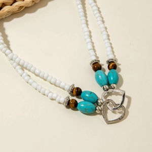 Detail of Bohemian beaded jewelry with turquoise beads, tiger eye stones and heart pendant