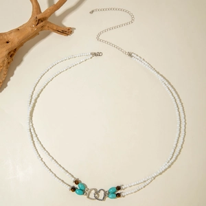 Detail of bohemian seed bead necklace with interlocking heart pendant and lobster clasp
