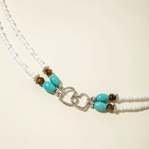 Detail of bohemian double-layer turquoise bead necklace with silver heart pendants