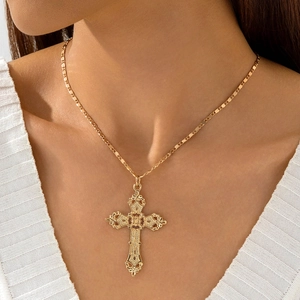 Detail of baroque hollow cross pendant with gold plating on a textured chain