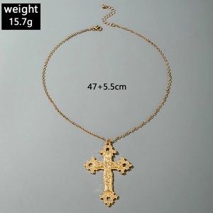 Detail of vintage gold hollow cross pendant with lobster clasp and adjustable extension chain