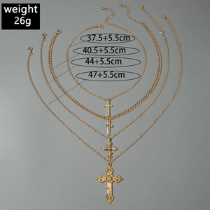 Detail of a 4-layer gold cross necklace set with rhinestones and vintage pendants