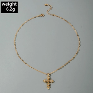 Detail of vintage gold cross necklace with zircon stones and adjustable lobster clasp