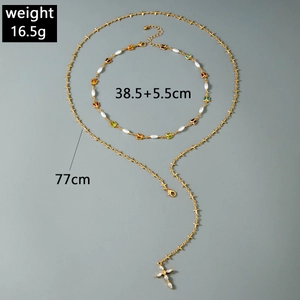 Détails du collier doré multicouche avec choker papillon en perles et pendentif croix