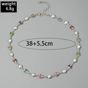 Détail de breloques papillons colorées et perles sur un collier en Y à plusieurs couches