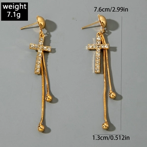 Détail des boucles d'oreilles croix dorées avec strass et spécifications de taille précises