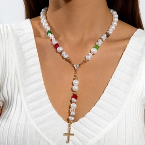 Collier en Y avec perles, cristaux colorés et pendentif croix dorée porté par un mannequin