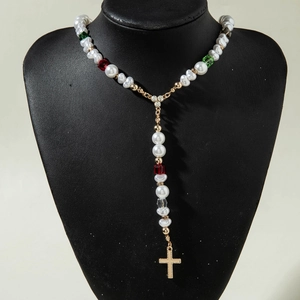 Détail du pendentif croix dorée avec perles de cristal colorées sur collier de perles