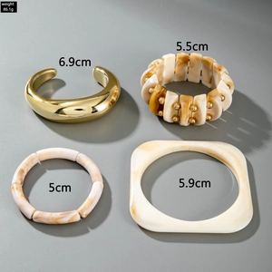 Detailed overhead view of chunky acrylic resin bangles and gold metal cuff bracelet set