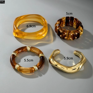 Detail view of mixed resin and gold metal bracelets set with weight and size specs