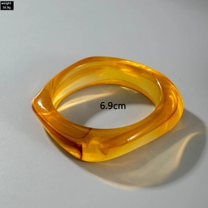 Macro detail of amber resin bangle with square edges and 6.9cm inner diameter