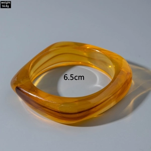 Detail view of amber resin bangle with 56.8g weight and 6.5cm inner diameter spec