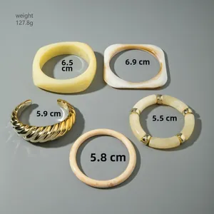 Detail of 5-piece chunky acrylic and metal bracelet set with marble textures and gold tones