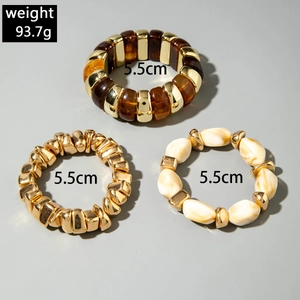 Detailed view of layered acrylic and gold beaded bracelets with size and weight info