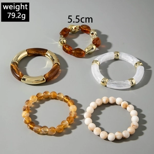 Detail of five-piece acrylic bracelet set including amber resin and gold metal beads