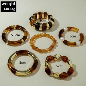 Detailed view of mixed acrylic resin bracelets set with amber beads and gold plating