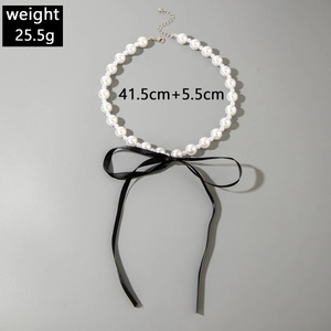 Detail of beaded pearl necklace with black velvet bow and adjustable silver clasp
