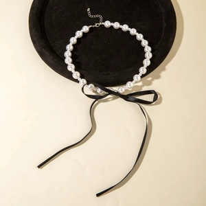 French style pearl necklace with black ribbon velvet bow on a black display tray
