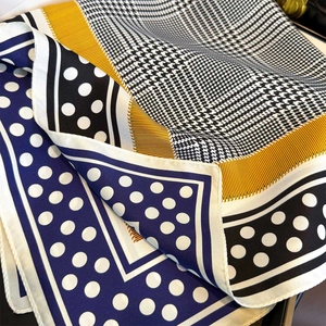 Detail of silk scarf with houndstooth, polka dots, and yellow border accents