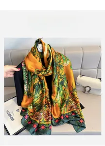 Detail of silk scarf with orange bamboo patterns draped over a black outfit