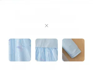 Détail du tissu en maille bleu clair avec broderie papillon et poignets côtelés de la robe
