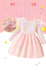 Détail du haut en tricot rose avec volants et jupe en tulle à étoiles pailletées