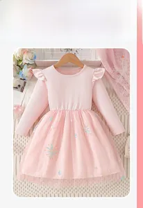 Détail de robe rose à manches longues avec épaules volantées et jupe en tulle pailletée