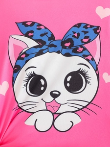 Close-up of cute white cat graphic with blue leopard bow and hearts on pink t-shirt
