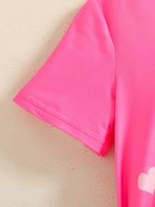 Detailed close-up of pink toddler shirt sleeve featuring a heart pattern and flat seams