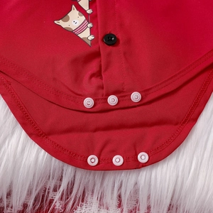 Detail of baby bodysuit snap button closure with cute cartoon cat print on red cotton fabric