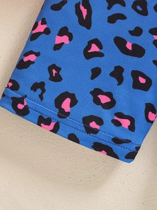 Detail of blue leopard print knit fabric with durable double-needle stitching on the hem