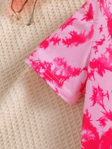 Close-up of pink tie-dye kids t-shirt with detailed stitching and pink sunglasses