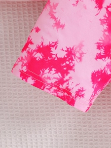 Detailed macro view of pink tie-dye fabric sleeve with reinforced double-needle stitching